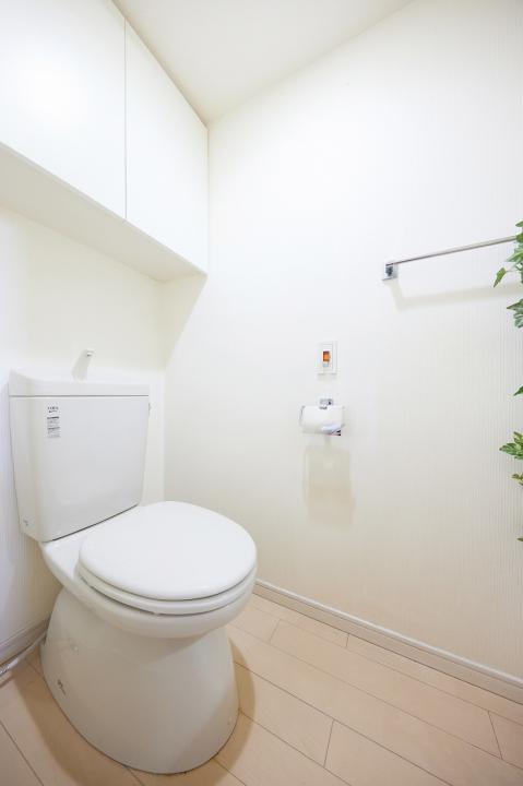シンプルなデザインのトイレには、日用品をストックできる吊戸棚がついております