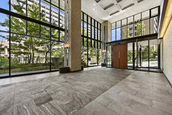 天井高のあるエントランスホール。ガラスウォールが採用され開放感があり、陽光差し込む明るい空間です。